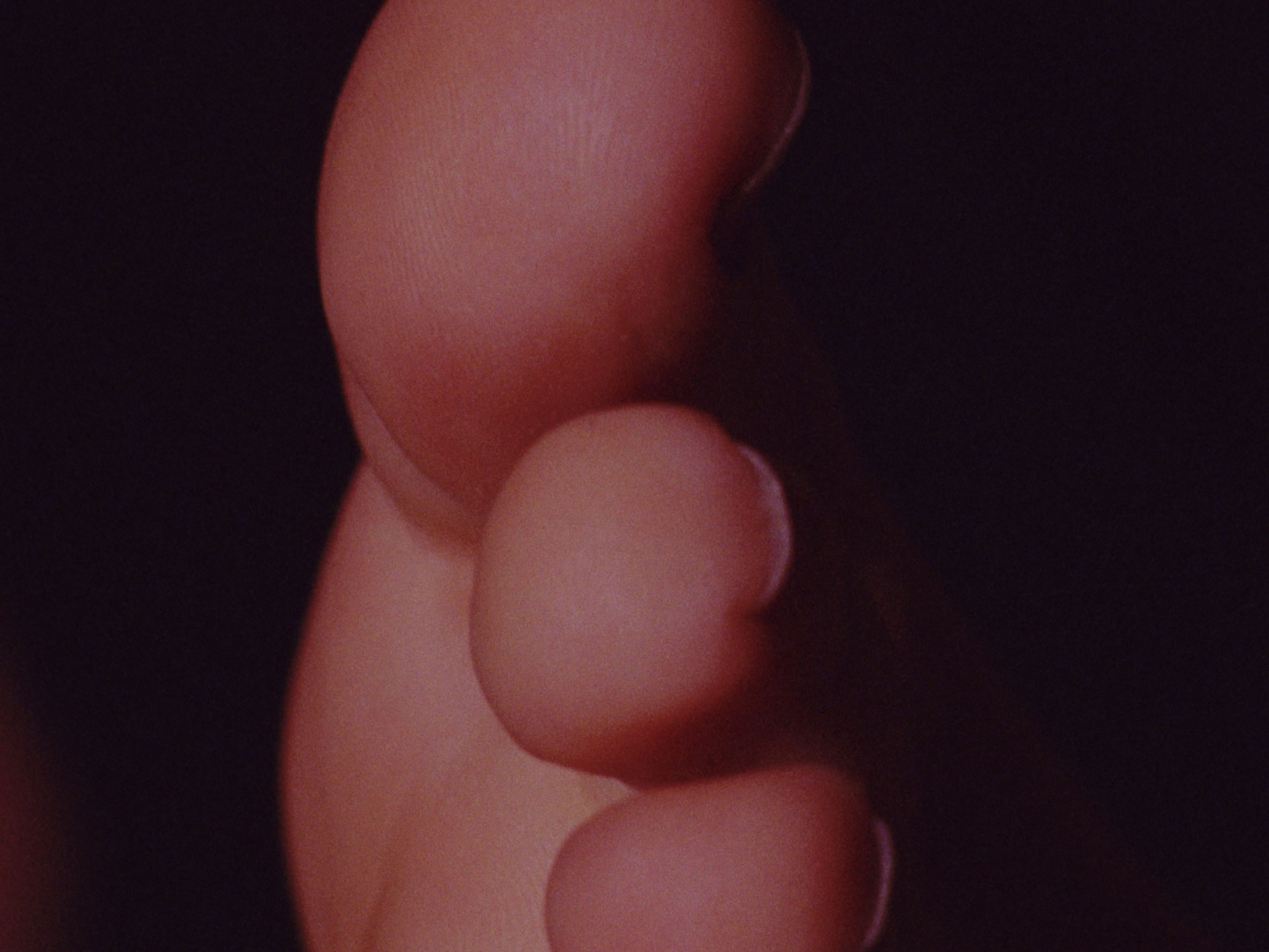 16 mm film still: a big toe over a black background